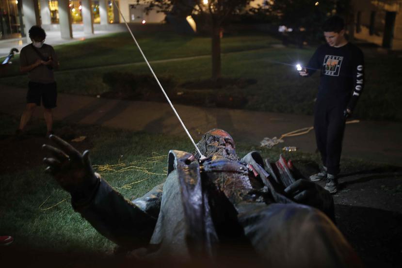 Un hombre usa su celular para grabar la estatua de Albert Pike, la única de un general del ejército confederado en la capital de Estados Unidos, después de que fue derribada por manifestantes e incendiada en Washington. (AP/Maya Alleruzzo)