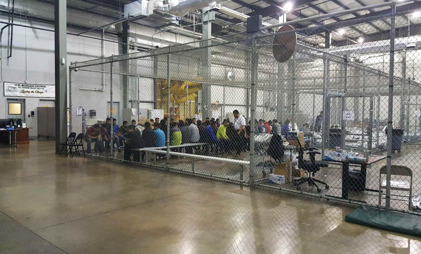 Personas que han sido detenidas por intentar entrar al país sin autorización, están sentadas en una de las jaulas en el centro de McAllen, Texas. (AP)