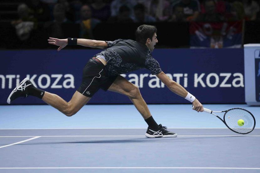 Novak Djokovic devuelve un tiro de John Isner durante su enfrentamiento en la Copa Masters. (AP / Tim Ireland)