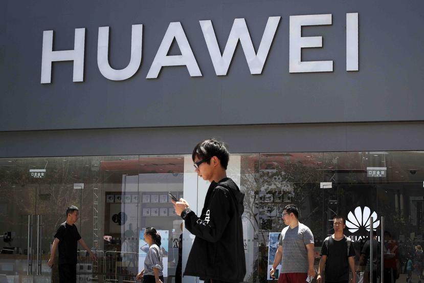 Unas personas pasan enfrente de una tienda de Huawei en Beijing. (AP)