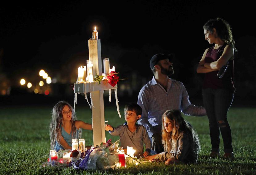Rich y Rachel Castleberry visitan con sus hijos una de las 17 cruces tras una vigilia por las víctimas de la balacera en la escuela secundaria Marjory Stoneman Douglas, en Parkland, Florida. (AP)