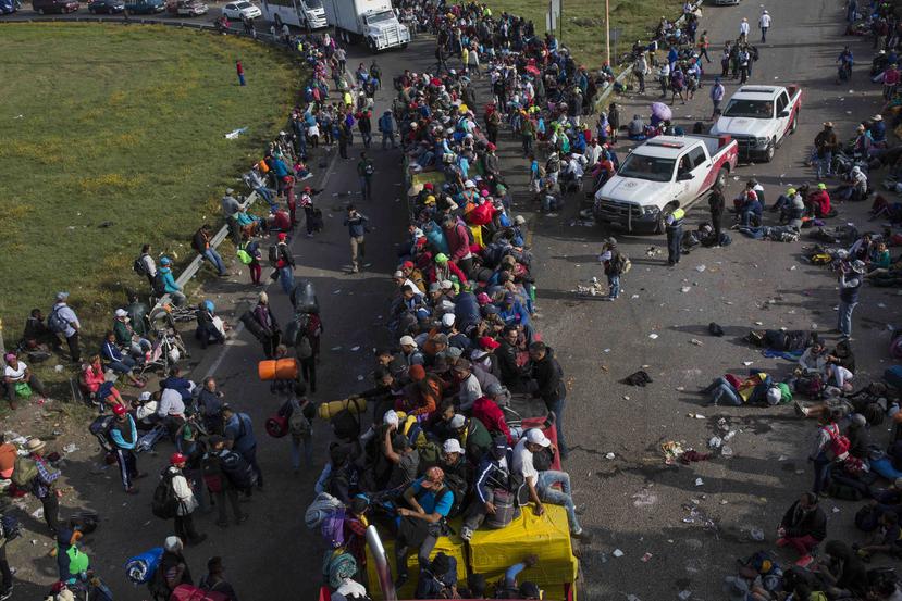 Autobuses interurbanos de Guadalajara custodiados por la policía trasladaron a muchos migrantes desde la frontera del estado de Jalisco hasta el auditorio habilitado para recibirlos. (AP)