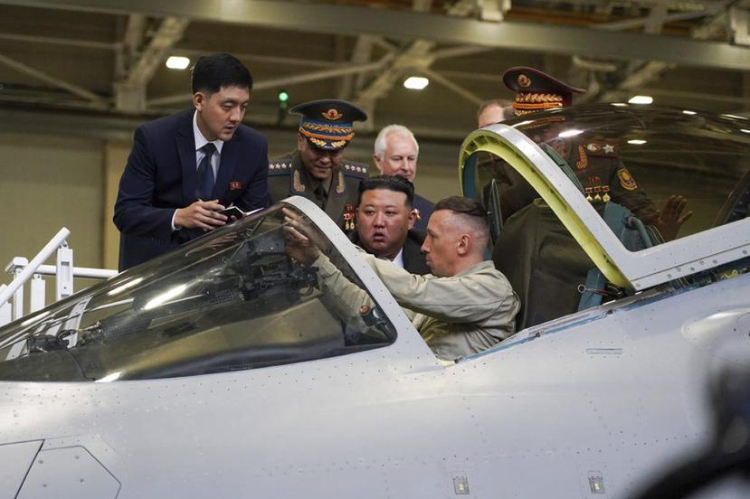 En esta imagen, distribuida en el canal de Telegram del gobernador de la región rusa de Khabarovsky Krai, Mikhail Degtyarev, se muestra al líder de Corea del Norte, Kim Jong-un (centro), observando la cabina de un avión de combate durante una visita a una planta de fabricación de cazas.