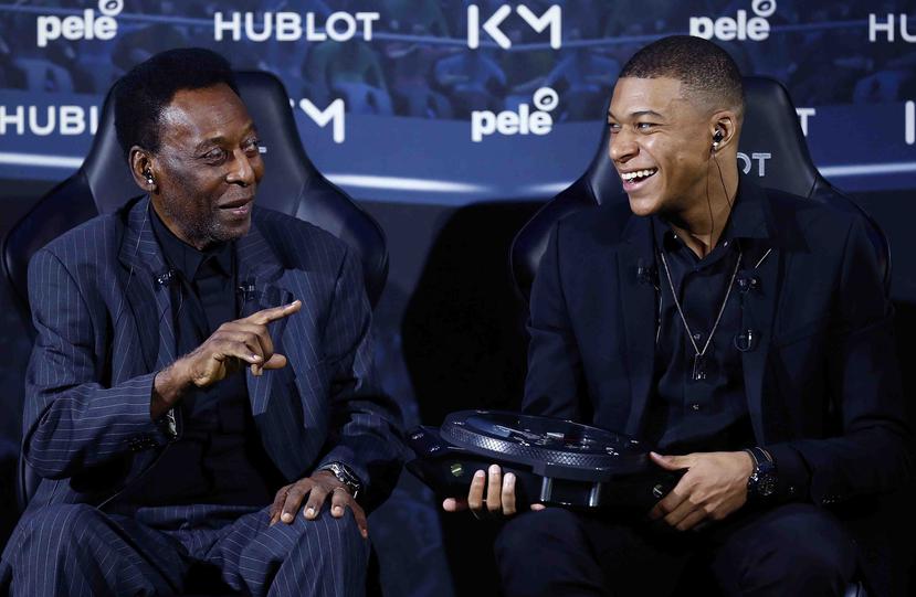 El legendario Pelé, izquierda, y el joven astro del fútbol francés Kylian Mbappé bromean durante un encuentro en París el martes, 2 de abril. (AP)