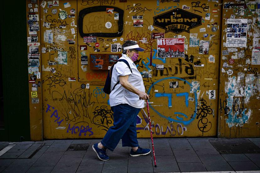 Una mujer camina con una mascara para evitar el contagio por coronavirus en Pamplona, España. (AP)