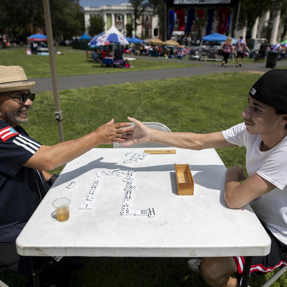 Charlie Ortiz y su nieto Marcial Ortiz juegan un partido de dominó. 