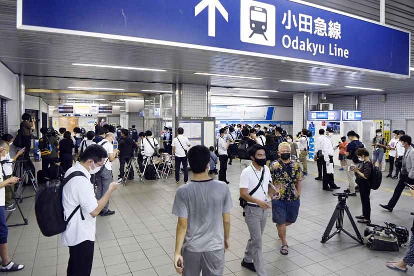La policía y reporteros se reúnen en la estación Soshigaya Okura luego de que una persona apuñaló a varios pasajeros en un tren de cercanías, el viernes 6 de agosto de 2021, en Tokio.