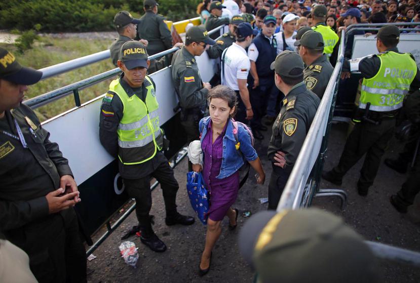 La Policía monta guarda mientras una mujer venezolana cruza hacia Colombia por el puente Simón Bolivar que conecta a San Antonio de Táchira, Venezuela con Cúcuta, Colombia. (Archivo AP /Ariana Cubillos).