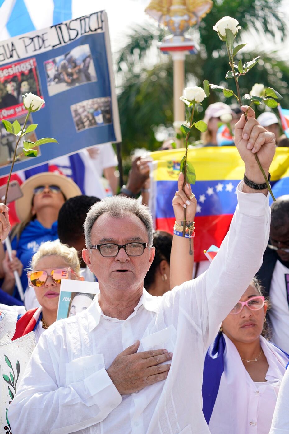 Cuban activist Ramón Saúl Sánchez holds a white rose while singing the National Anthem and protesters gather to support protests in Cuba.