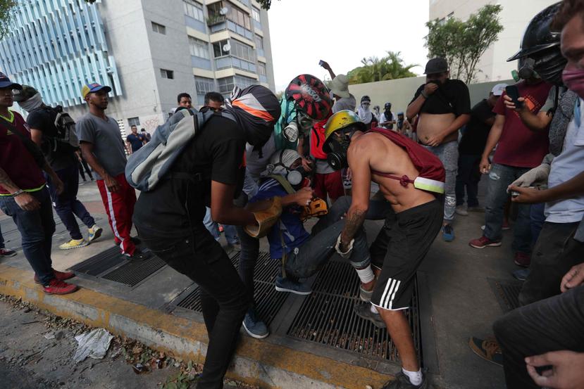Manifestantes antichavistas ayudan a un herido, durante las manifestaciones contra el gobierno de Nicolás Maduro, en Caracas. (EFE)