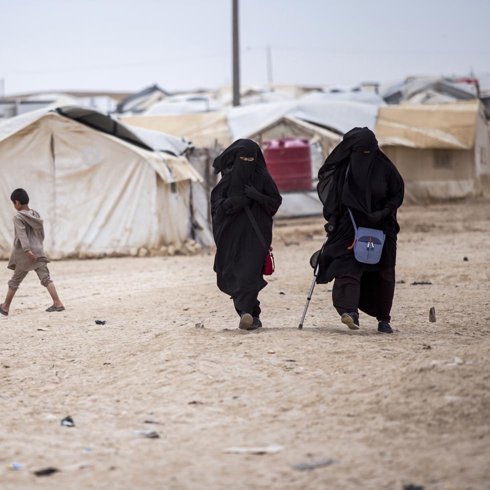 Mujeres caminan por el campamento de al-Hol, Siria, que alberga a unos 60,000 refugiados, incluyendo mujeres y niños vinculados con el grupo extremista Estado Islámico.