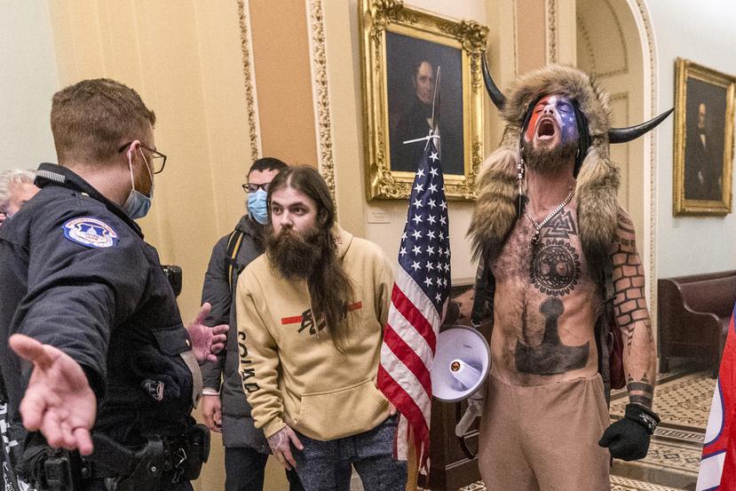 Jacob Chansley, derecha con gorra con cuernos, participa en el asalto al Capitolio, 6 de enero de 2021.