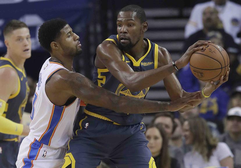 El jugador de los Warriors de Golden State Kevin Durant (derecha), presionado por su rival del Thunder de Oklahoma City Paul George. (AP)