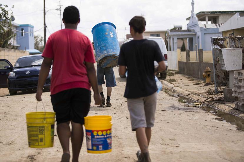 Vecinos de Toaville, en busca de agua tras el paso del huracán María.