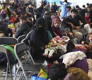 Refugiados afganos esperan a ser procesados dentro del hangar 5 en la base aérea Ramstein, en Alemania.