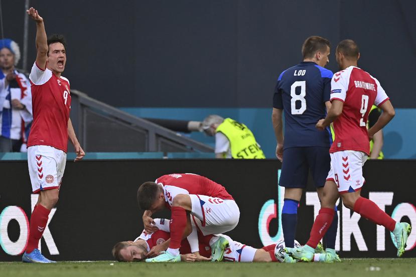 Jugadores de la selección de Dinamarca tratan de socorrer a su compañero Christian Eriksen, quien se desvaneció durante un partido de la Eurocopa ante Finlandia, el sábado 12 de junio en Copenhague.
