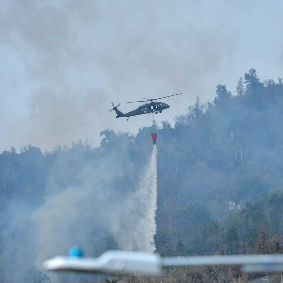 Helicóptero de la Guardia Nacional echa agua en el área del fuego forestal en Gurabo.