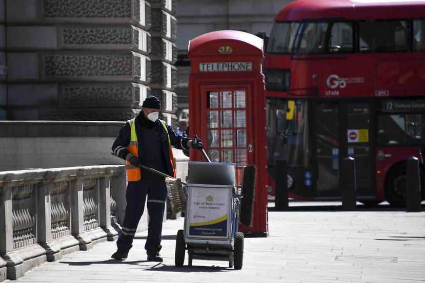 Un hombre recoge basura en la Plaza del Parlamento, en Londres. (AP)