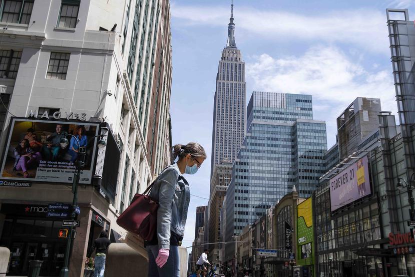 Una mujer camina por una de las avenidas cerca del Empire State Building en Nueva York. (EFE)