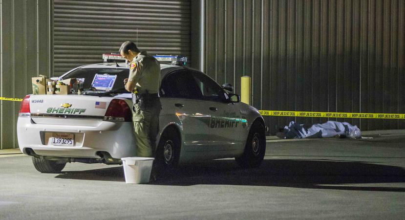 Un oficial recolecta evidencia cerca de una de las víctimas de la masacre. (Felix Adamo / The Bakersfield Californian vía AP)