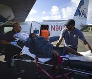 Paramédicos meten a Sandra Medina, una paciente de diálisis de 42 años, en un avión en Vieques, antes de viajar a Ceiba para recibir tratamiento en la clínica Fresenius de Humacao. (AP)