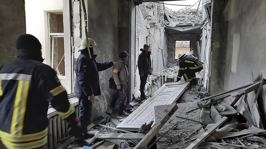 Esta foto difundida por el Servicio de Emergencia de Ucrania muestra al personal del servicio de emergencia inspeccionando los daños dentro del edificio del Ayuntamiento en Kharkiv, Ucrania, el martes 1 de marzo de 2022. 