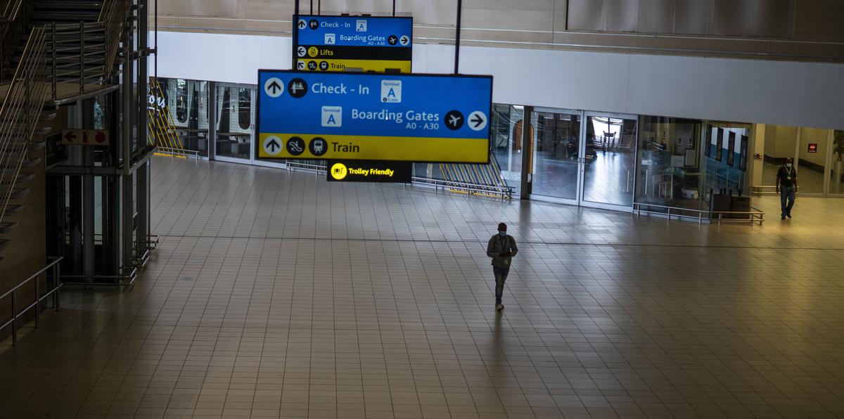 Un hombre camina por una terminal desierta del aeropuerto OR Tambo de Johannesburgo.