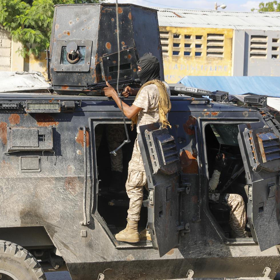 Policías se cobijan durante una operación antipandillas en Puerto Príncipe, Haití, el viernes.