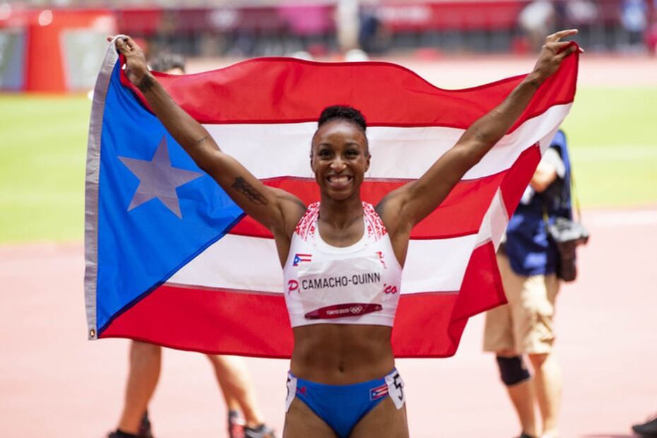 Camacho-Quinn levanta la bandera de Puerto Rico luego de su triunfo.