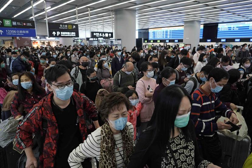 Personas usan máscaras protectoras en un tres de Hong Kong. (AP)
