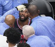 Joel Embiid, pívot de los 76ers de Filadelfia, recibe atención tras sufrir un golpe en el rostro durante el sexto partido de la serie de playoffs ante los Raptors de Toronto, el jueves 28 de abril de 2022
