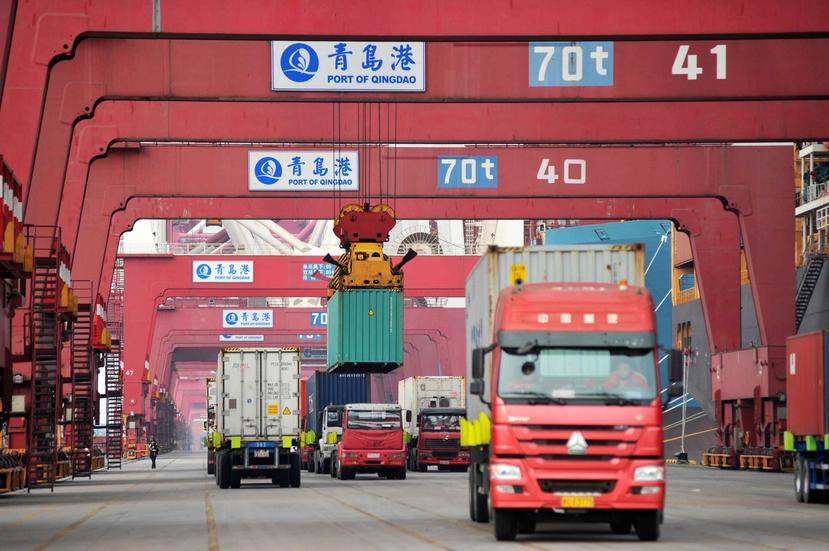 Varios camiones mientras transportan contenedores en un puerto en Qingdao, China. (AP)
