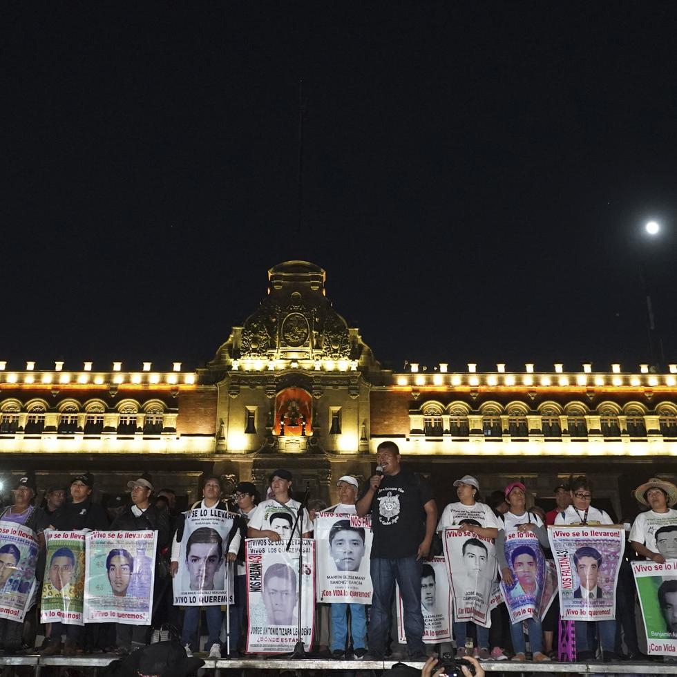 Familiares de los 43 estudiantes desaparecidos de Ayotzinapa con carteles con las imágenes y nombres de sus parientes, en el noveno aniversario de su desaparición, frente al Palacio Nacional en Ciudad de México, el 26 de septiembre de 2023. (Archivo)