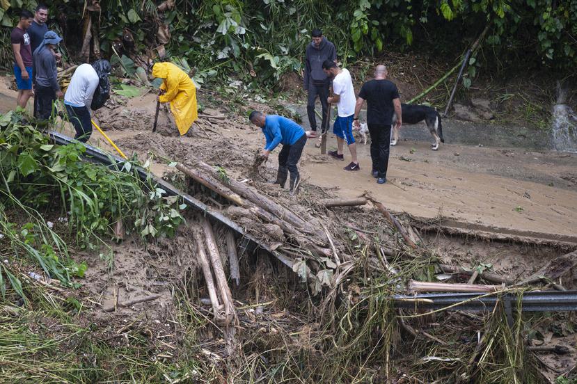 En la foto, ciudadanos intentan abrir un camino en Utuado que quedó tapado debido a un deslizamiento producto de las lluvias de Fiona.