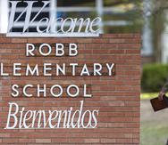 Un policía estatal pasa frente al letrero de la Escuela Primaria Robb en Uvalde, Texas, el 24 de mayo de 2022, luego del tiroteo mortal.