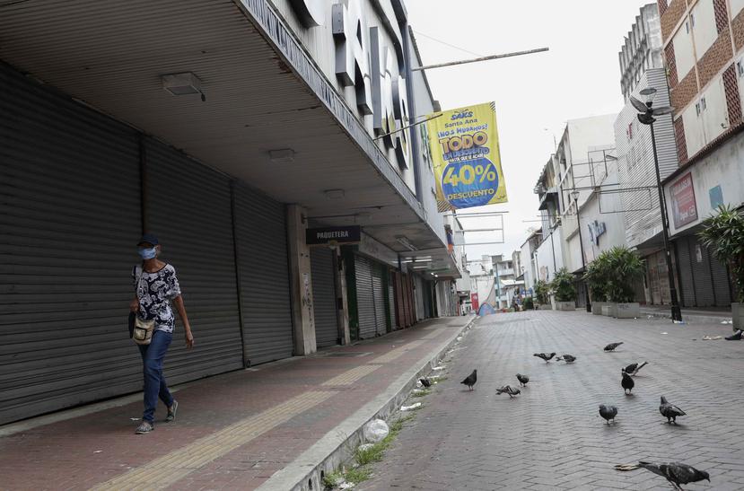 Una mujer camina por al frente de un supermercado cerrado durante la pandemia en Panamá. (AP)