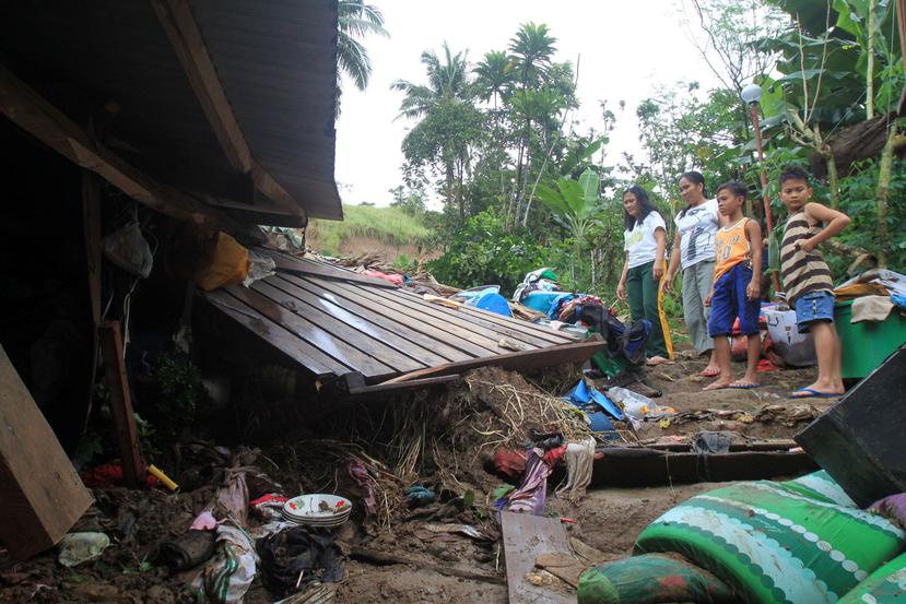 Residentes filipinos miran sobre su casa dañada en la comunidad afectada por los deslizamientos de tierra en Bulan, provincia de Sorsogon, Filipinas. (Agencia EFE)