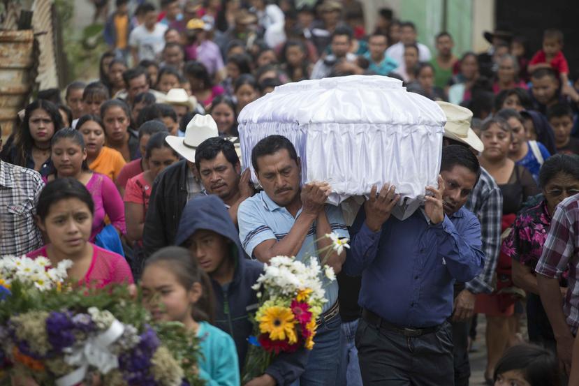 Varias personas cargan con el féretro de Roselia Pérez Junay, de 14 años y una de las víctimas del incendio del Hogar Seguro Virgen de la Asunción, en el cementerio de Zaragoza, Guatemala. (Archivo/AP)