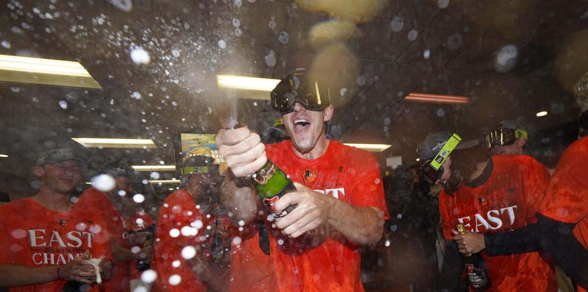 El lanzador de los Orioles de Baltimore, John Means, (centro) celebra junto a su equipo la conquista del campeonato.