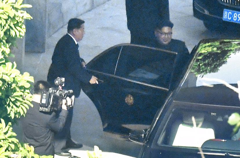 El líder de Corea del Norte, Kim Jong Un (derecha), entra en un auto tras visitar la embajada de su país en Beijing. (Kyodo News via AP)
