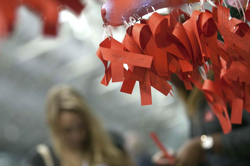 Varias cintas rojas con mensajes sobre el VIH. (Agencia EFE)
