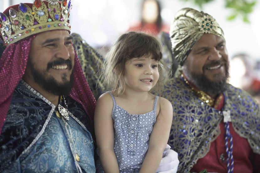 Dos de los tres reyes magos de Juana Díaz comparten con una niña.