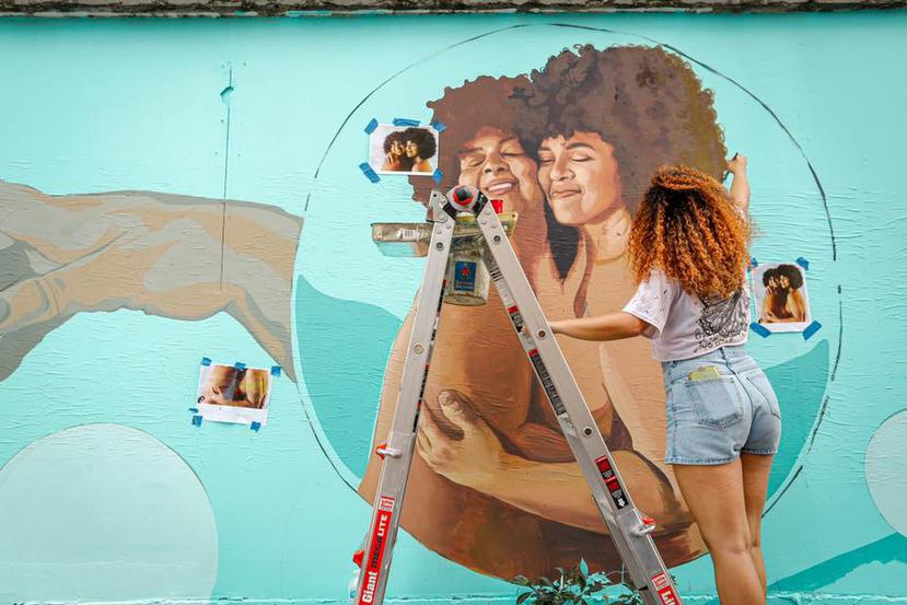 Raysa Rodríguez, del Colectivo Moriviví,  trabaja en el mural junto a sus colegas Sharon González y Salomé Cortés. (Suministrada / Jessica Cristina Colón)