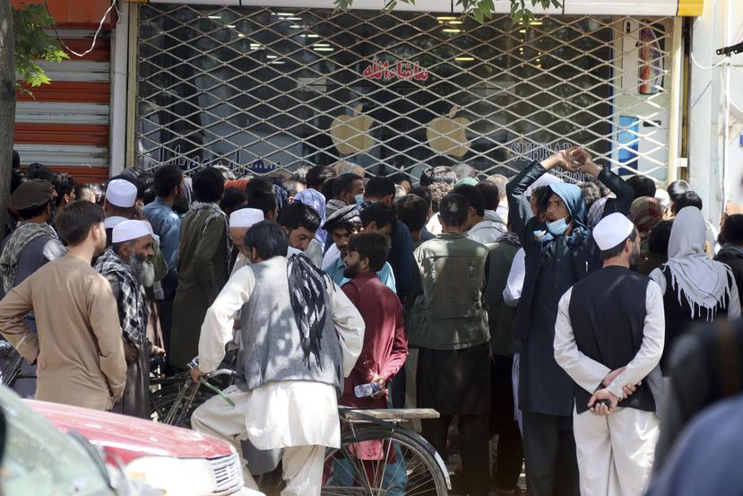 Afganos esperan durante horas para retirar dinero ante el Banco de Kabul, en Kabul, Afganistán.