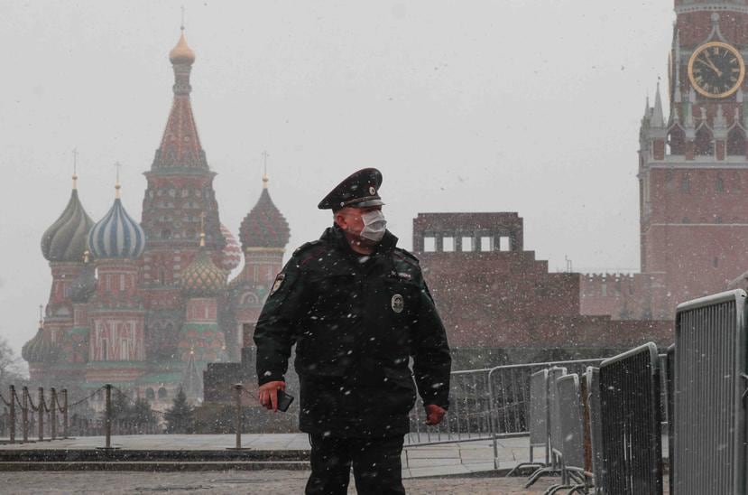 Un policía con máscaras protectoras camina por la Plaza Roja frente al Kremlin en Moscú, Rusia. (EFE)