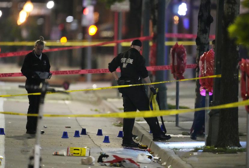 Investigadores del Departamento de Policía de Denver, trabajan en la escena de un tiroteo masivo en Market Street, entre la 20ma y la 21ra avenidas, durante al celebración del título de la NBA de los Nuggets en Denver.