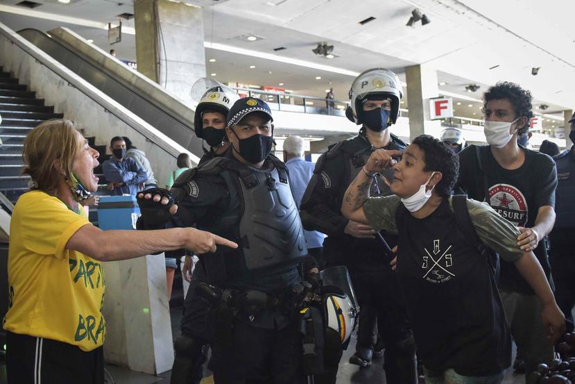 Oficiales de la policía militar brasileña separan a los manifestantes leales al presidente de Brasil, Jair Bolsonaro, y a los manifestantes antigubernamentales, justo después de una protesta contra el racismo. (AP)