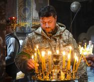 Un soldado ucraniano enciende velas en la Catedral Volodymysky durante la celebración de la Pascua en Kiev, Ucrania.
