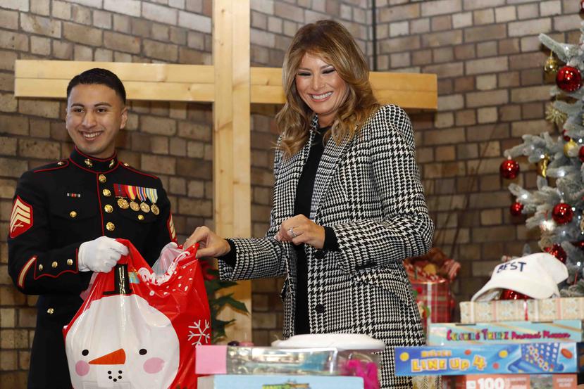 En esta foto de archivo del 4 de diciembre de 2019, la primera dama Melania Trump junto con estudiantes locales y marines estadounidenses asignados a la embaja estadounidense en Londres prepara regalos navideños para donar. (AP/Alastair Grant, Pool)