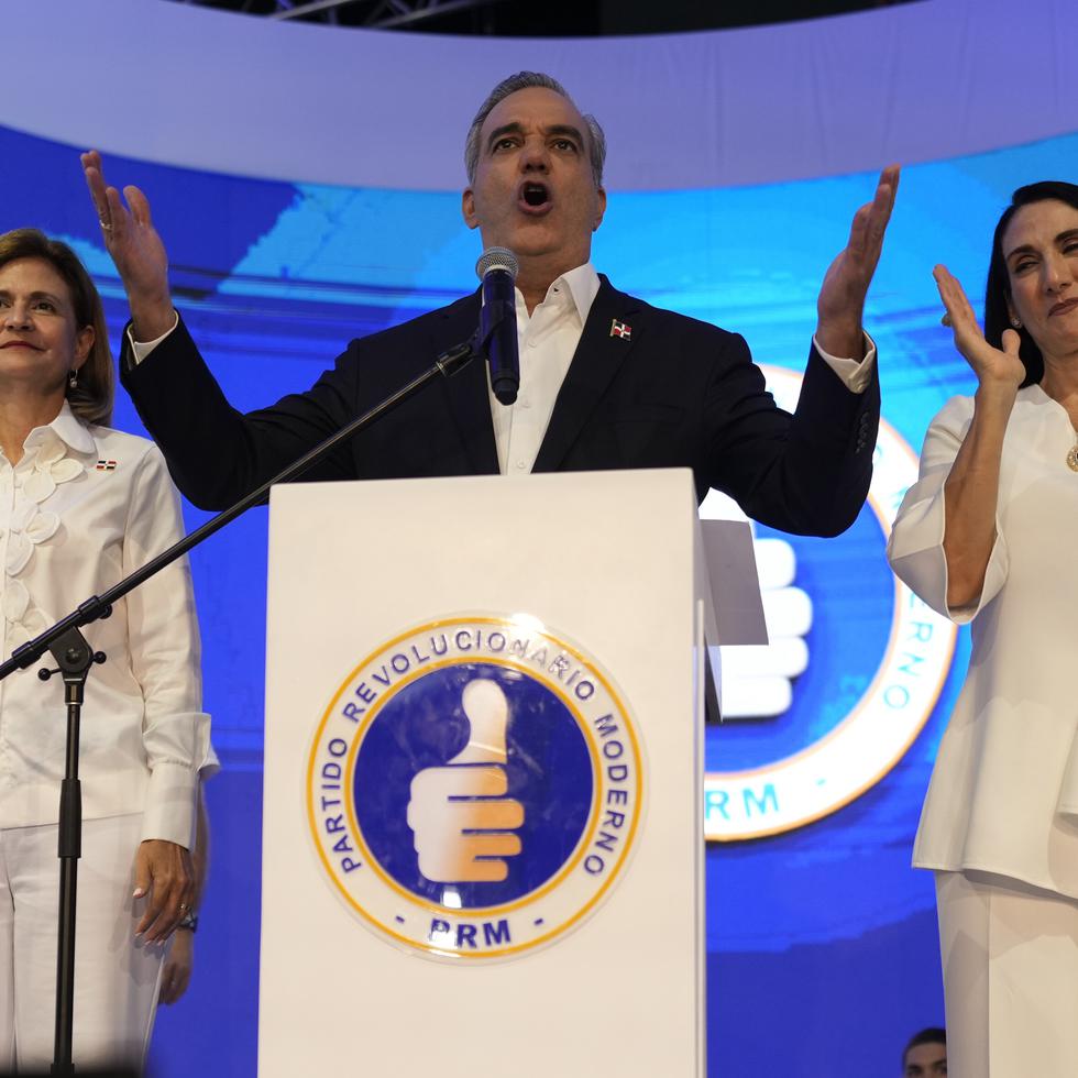 El presidente Luis Abinader, flanqueado por la candidata a la vicepresidencia Raquel Peña (izquierda) y su esposa, Raquel Arbaje (derecha), se dirigió a sus seguidores el domingo en la noche.